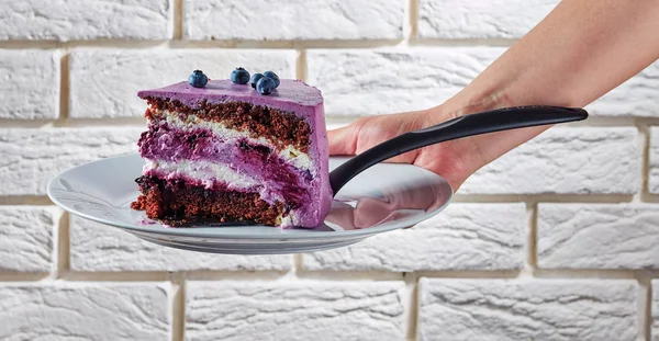 Una mano de mujer sosteniendo una porción de pastel —  Fotos de Stock
