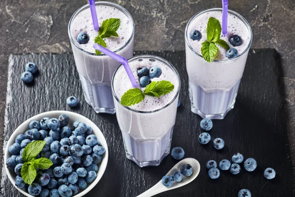 3つのグラスで新鮮なブルーベリー泡立つミルクセーキ — ストック写真