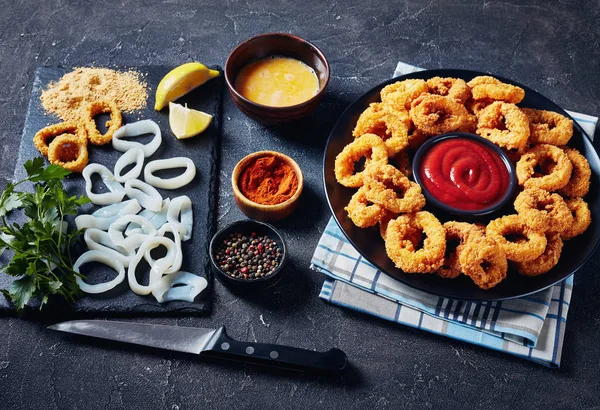 Anillos de calamares crujientes en un plato negro —  Fotos de Stock