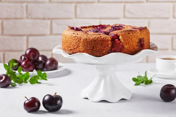 Plum torte on a white cake stand — Stock Photo, Image