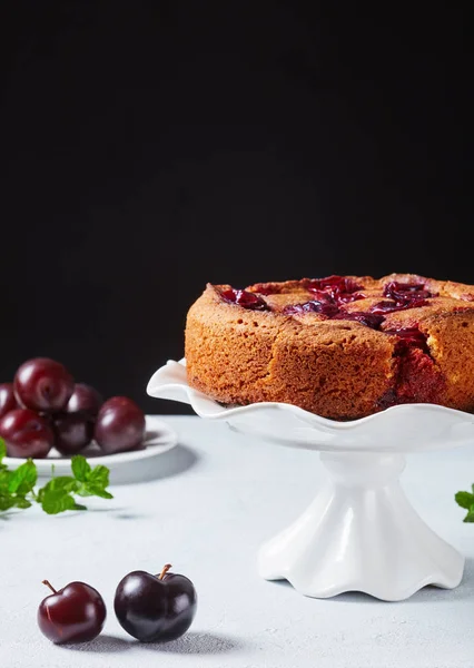 Plum torte on a white cake stand — Stock Photo, Image