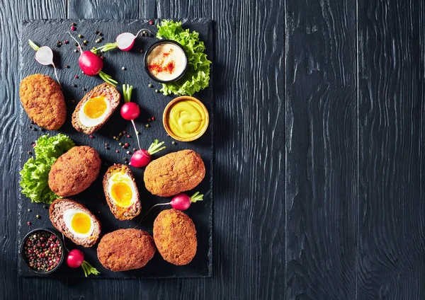 classic deep fried scotch eggs on a stone tray