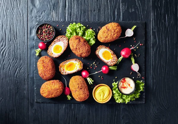 classic deep fried scotch eggs on a stone tray