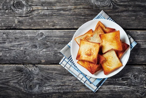 Toasts of wheat bread on a white platter — Stock Photo, Image