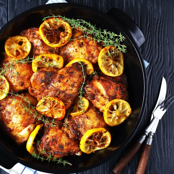 Muslos de pollo con rodajas de limón en una sartén — Foto de Stock