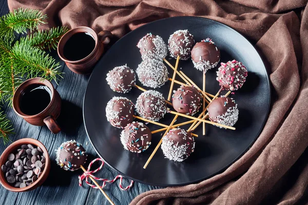 cake pops on a plate with fir limbs on a table