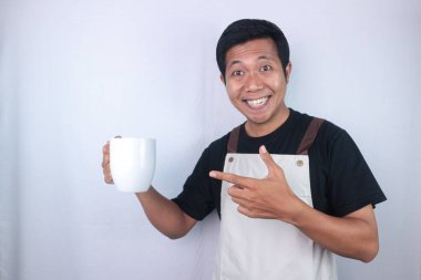 Excited face expression asian man wearing apron holding coffee cup isolated white background