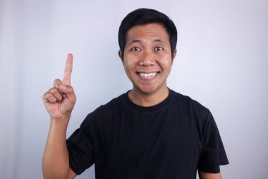 Smiling face expression asian man giving one finger signs isolated on white background.