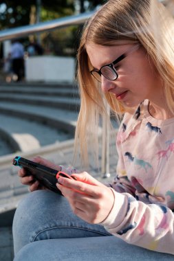 Anapa, Rusya Federasyonu - 2 Mayıs 2018, Genç kız Nintendo anahtarı konsolda oyun oynama. El Nintendo anahtarıyla açık çocuk. 