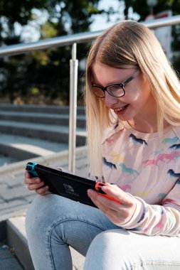 Anapa, Rusya Federasyonu - 2 Mayıs 2018, Genç kız Nintendo anahtarı konsolda oyun oynama. El Nintendo anahtarıyla açık çocuk. 