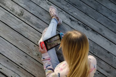 Anapa, Rusya Federasyonu - 2 Mayıs 2018, Genç kız Nintendo anahtarı konsolda oyun oynama. El Nintendo anahtarıyla açık çocuk. 