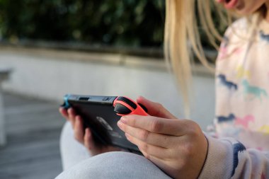 Anapa, Rusya Federasyonu - 2 Mayıs 2018, Genç kız Nintendo anahtarı konsolda oyun oynama. El Nintendo anahtarıyla açık çocuk. 
