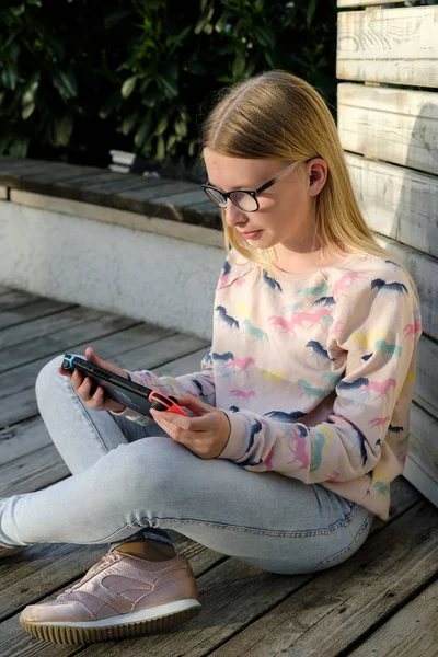 Anapa, Rusya Federasyonu - 2 Mayıs 2018, Genç kız Nintendo anahtarı konsolda oyun oynama. El Nintendo anahtarıyla açık çocuk. 