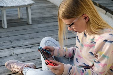 Anapa, Rusya Federasyonu - 2 Mayıs 2018, Genç kız Nintendo anahtarı konsolda oyun oynama. El Nintendo anahtarıyla açık çocuk. 