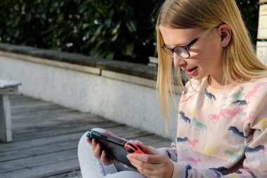 Genç kız Nintendo anahtarı konsolda oyun oynama. El Nintendo anahtarıyla açık evlat. yeşil ekran