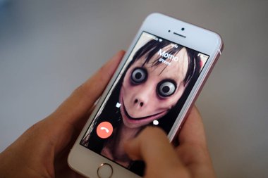 Anapa, Rusya Federasyonu - 9 Ağustos 2018, Momo telefonla aramayı kadın iblis var. Kadın korkunç bir yaratılış telefon aramayý cevaplar. Ölü kız cep telefonunda iri gözlü. Cadılar Bayramı karakter