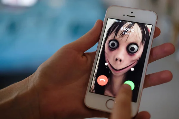 Anapa, Rusya Federasyonu - 9 Ağustos 2018, Momo telefonla aramayı kadın iblis var. Kadın korkunç bir yaratılış telefon aramayý cevaplar. Ölü kız cep telefonunda iri gözlü. Cadılar Bayramı karakter
