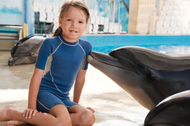 Şişe burunlu yunus ile evlat. Küçük kız ve yunus sahnede. Yunus terapisi destekli