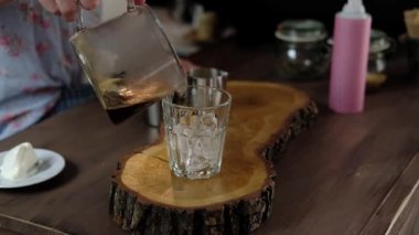 Amerikan kahve bir bardak buz içine dökme ve süt ve buzdan ibaret ekleme Barista. barista kahve frappe bir kafede hazırlanıyor. Yumuşak odak