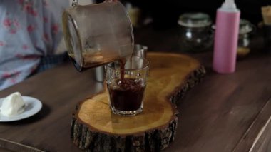 Amerikan kahve bir bardak buz içine dökme ve süt ve buzdan ibaret ekleme Barista. barista kahve frappe bir kafede hazırlanıyor. Yumuşak odak