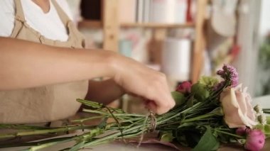 Profesyonel çiçek sanatçı, çiçekçi çiçek dükkanında kaynaklanıyor bağlama Atölyesi. Kadın çiçekçi buket hazırlanıyor. Floristik, el yapımı ve küçük işletme, Girişimcilik kavramı. Yakın çekim