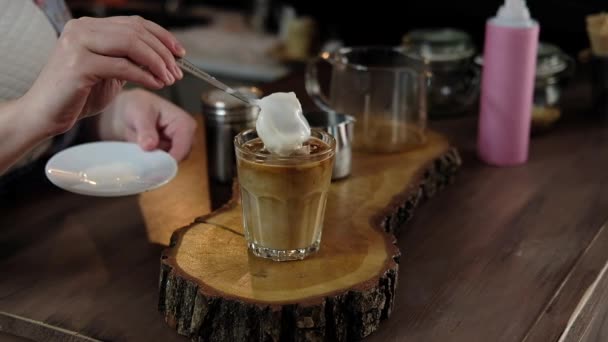バリスタ アメリカン コーヒーを注ぐグラスに氷とミルク ホイップ クリーム アイスクリームを追加します バリスタ カフェでコーヒー フラッペを準備します ソフト — ストック動画
