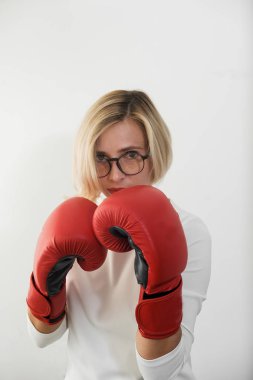 Genç kadın kırmızı boks eldivenli. Kırmızı elbiseli kız mücadele, saldıran ve koruma. Feminizm, kız güç, mücadele kız, cinsiyet, kadın hakları kavramı gibi 
