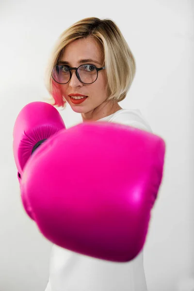 young woman with pink boxing gloves. Girl in red dress are fighting, attacking and protecting.  Feminism, girl power, fight like girl, gender, woman rights concept