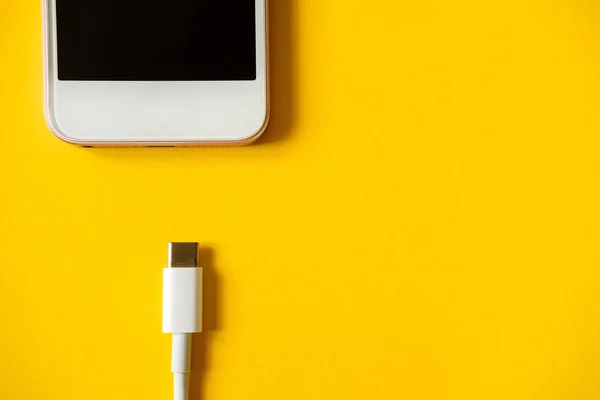 Smartphone Conecta Cargador Través Del Cable Fondo Amarillo Vista Superior — Foto de Stock