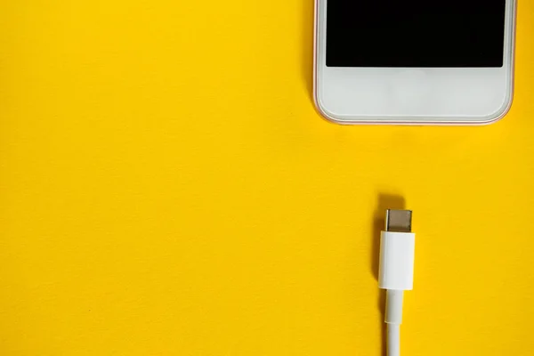 Smartphone Conecta Cargador Través Del Cable Fondo Amarillo Vista Superior — Foto de Stock