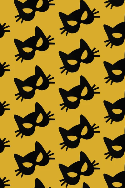 Kağıt kedi maskesi desen sarı zemin üzerine. Cadılar Bayramı, karnaval, maskeli balo kavramı.