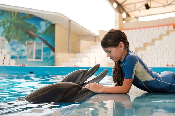 kız mavi su şişe burunlu yunuslar ile yüzme. Yunus terapisi destekli