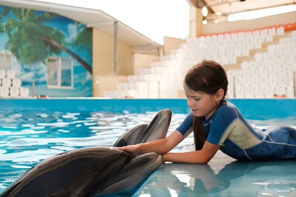 kız mavi su şişe burunlu yunuslar ile yüzme. Yunus terapisi destekli