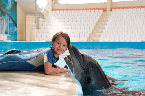 kız mavi su şişe burunlu yunuslar ile yüzme. Yunus terapisi destekli