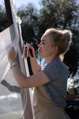 Zımba perde avlu üzerinde asılı olan kadın. Kadın tasarımcı tatil için hazırlık düğün kemer açık havada, dekorasyon