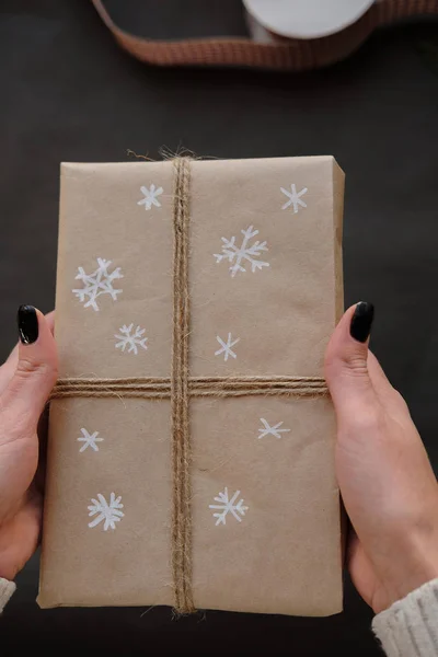 Woman holding Christmas box Gift on black background. Female hands with Presents for winter Holidays. Christmas, New Year, shopping, preparation on Holidays, donation concept