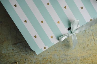 Christmas gift box on golden background. Striped Present near Christmas tree. Close up. Copy space clipart