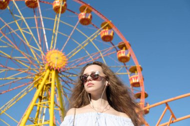 Dönme dolap karşı güzel genç kadın portresi. Kız eğlence parkı