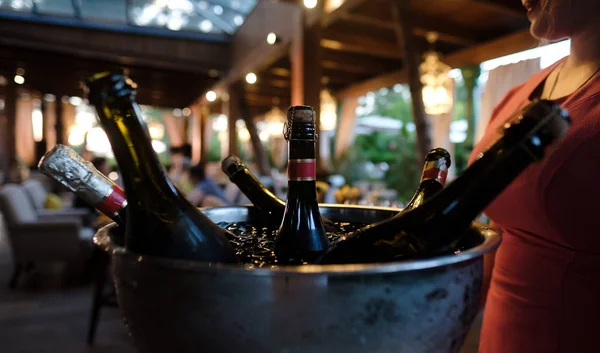 Bottle of Wine in ice bucket in Restaurant in Dinner Party. Cold bottle Champagne