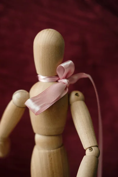 Wooden Artist Mannequin Pink Ribbon Burgundy Background — Stock Photo, Image