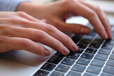 Evde çalışan bir blog yazmaya dizüstü kadınla. Eller üstünde belgili tanımlık klavye. Yakın çekim