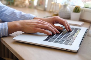Evde çalışan bir blog yazmaya dizüstü kadınla. Eller üstünde belgili tanımlık klavye. Yakın çekim