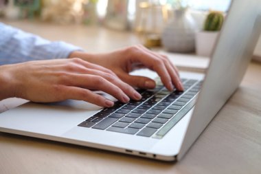 Evde çalışan bir blog yazmaya dizüstü kadınla. Eller üstünde belgili tanımlık klavye. Yakın çekim