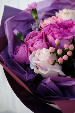 pembe ve Mor gül buketi. kadın buket çiçek dükkanında hazırlanıyor. Yakın çekim. Anneler günü ve Sevgililer günü kavramı 