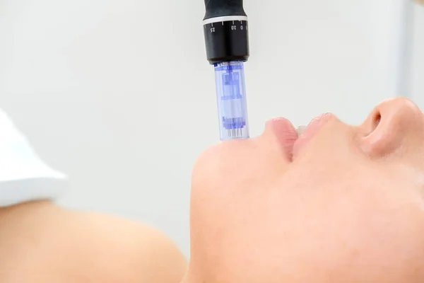 Kozmetik uzmanı mesoterapi enjeksiyonu yapıyor. Mikro-edle mezoterapi. Güzellik uzmanında tedavi gören kadın. Donanım kozmetolojisi. Mezoterapi, cilt bakımı, yüz bakımı, yüz yenileme. Kapat.