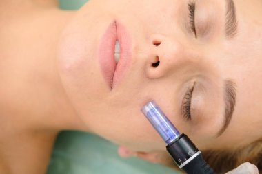 Cosmetologist making mesotherapy injection. Microneedle mesotherapy. Treatment woman at beautician. Hardware cosmetology. Mesotherapy, dermapen, treatment of face zone, face rejuvenation.  Close up clipart