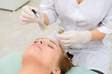 Güzellik uzmanı ve güzellik salonları içinde Bayan hasta. Hyaluronik asit, hidrasyon cilt, şişe, Botox bırakır. Yüz tedavi özü cilt bakımı kozmetik, yüz gençleştirme. Yakın çekim