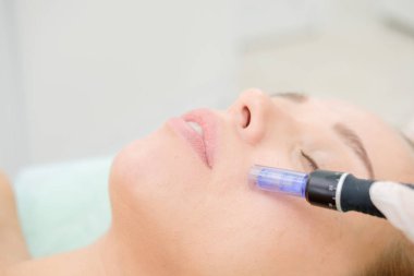 Cosmetologist making mesotherapy injection. Microneedle mesotherapy. Treatment woman at beautician. Hardware cosmetology. Mesotherapy, dermapen, treatment of face zone, face rejuvenation.  Close up clipart