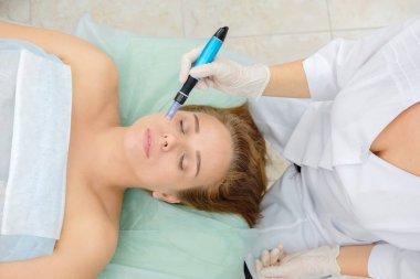 Kozmetik uzmanı mesoterapi enjeksiyonu yapıyor. Mikro-edle mezoterapi. Güzellik uzmanında tedavi gören kadın. Donanım kozmetolojisi. Mezoterapi, cilt bakımı, yüz bakımı, yüz yenileme. Kapat.