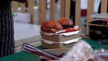 Ambalaja yığılmış hamburger pişirme. Fast food, sokak gıda, sağlıksız diyet